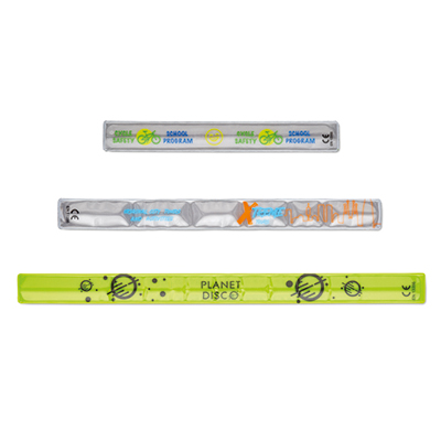 ML4001_A V2 Τρεις διαφορετικοί τύποι ανακλαστικών λωρίδων σε λευκή επιφάνεια. Αυτές οι αντανακλαστικές ταινίες μπορούν να χρησιμεύσουν ως διαφημιστικά είδη για εταιρικά δώρα, καθώς μπορούν να προσαρμοστούν με τυπωμένα λογότυπα ή σχέδια.